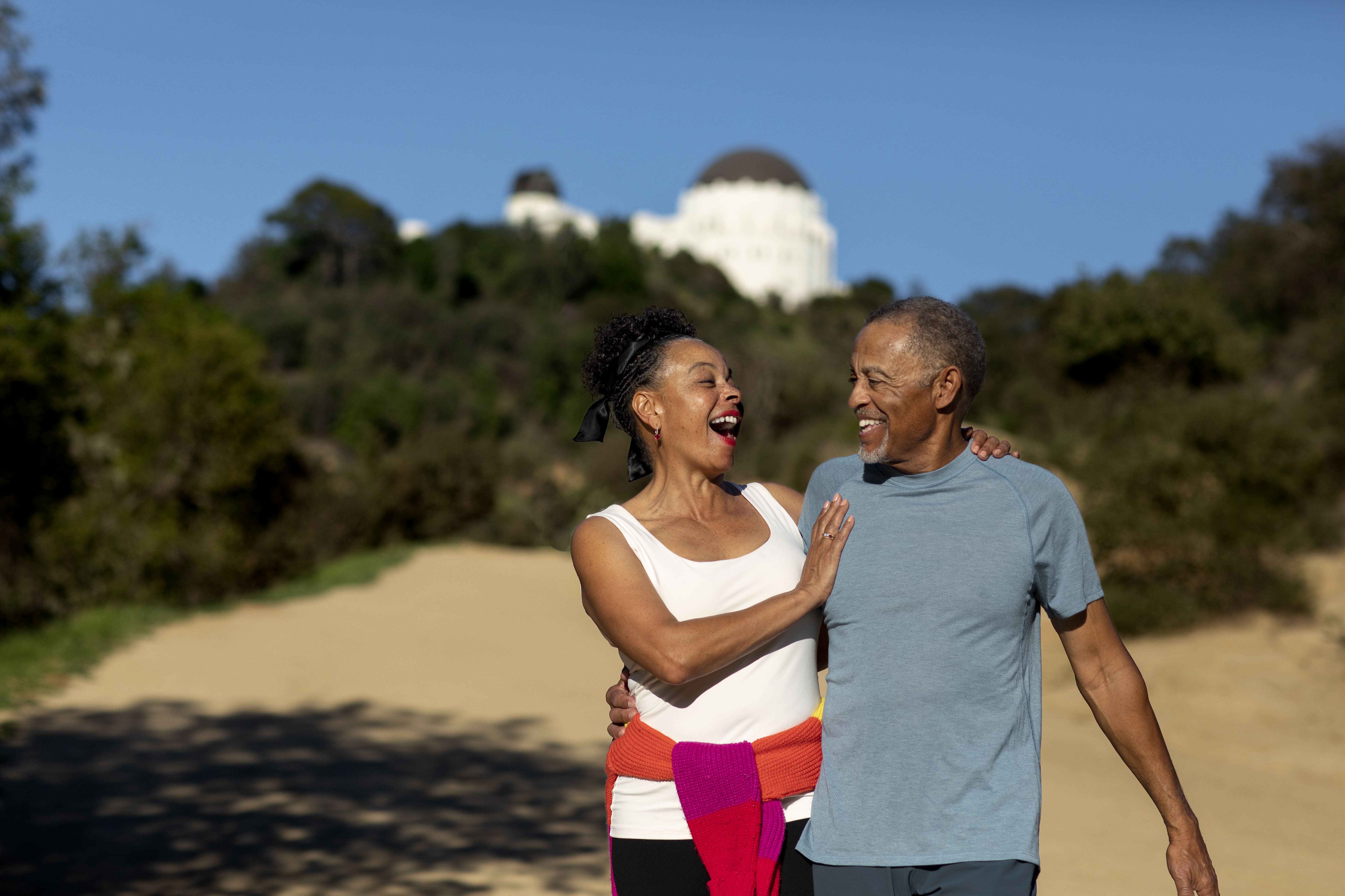 Two seniors taking a walk and laughing.